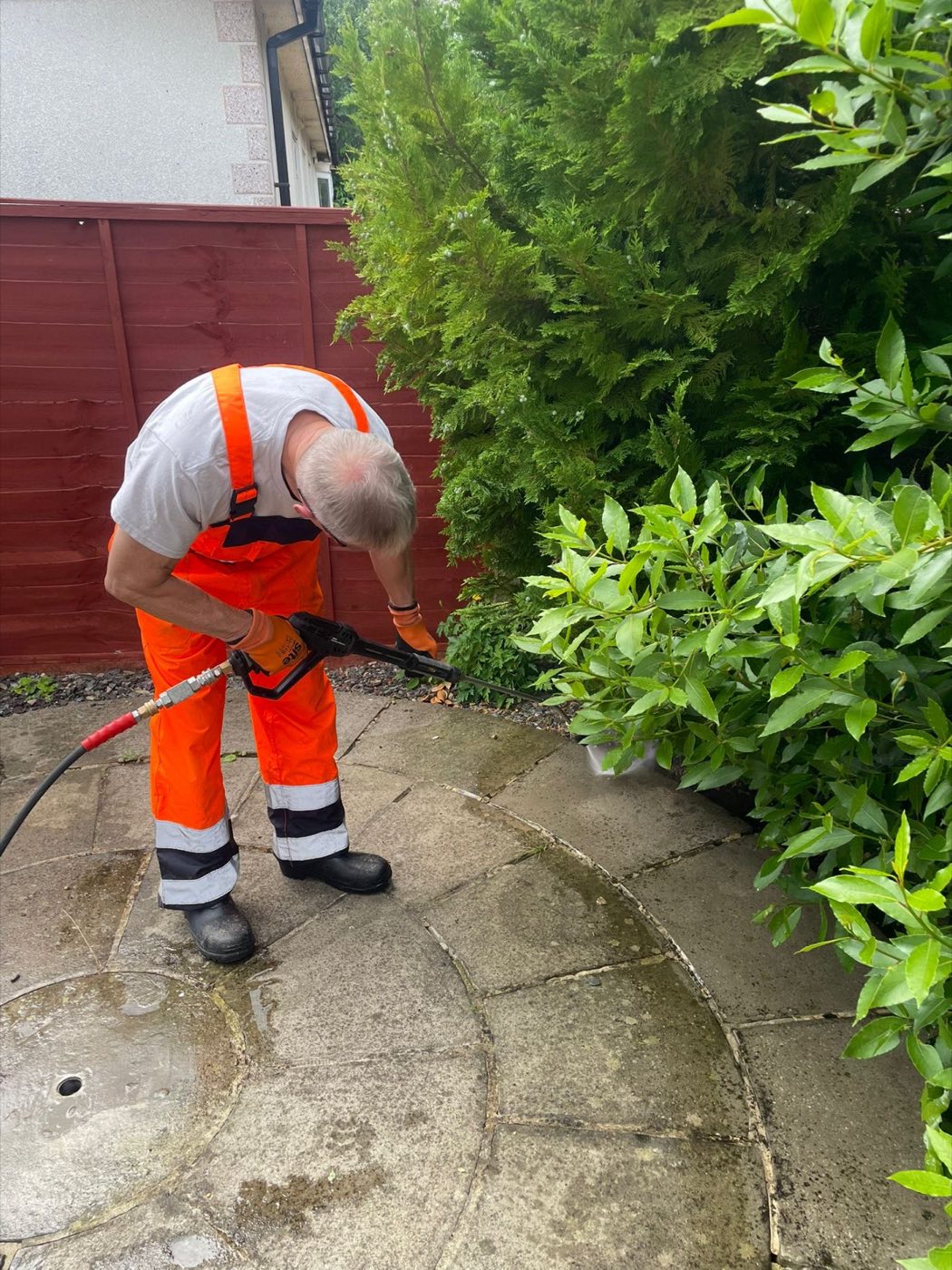 Pressure washing a circular stone patio feature