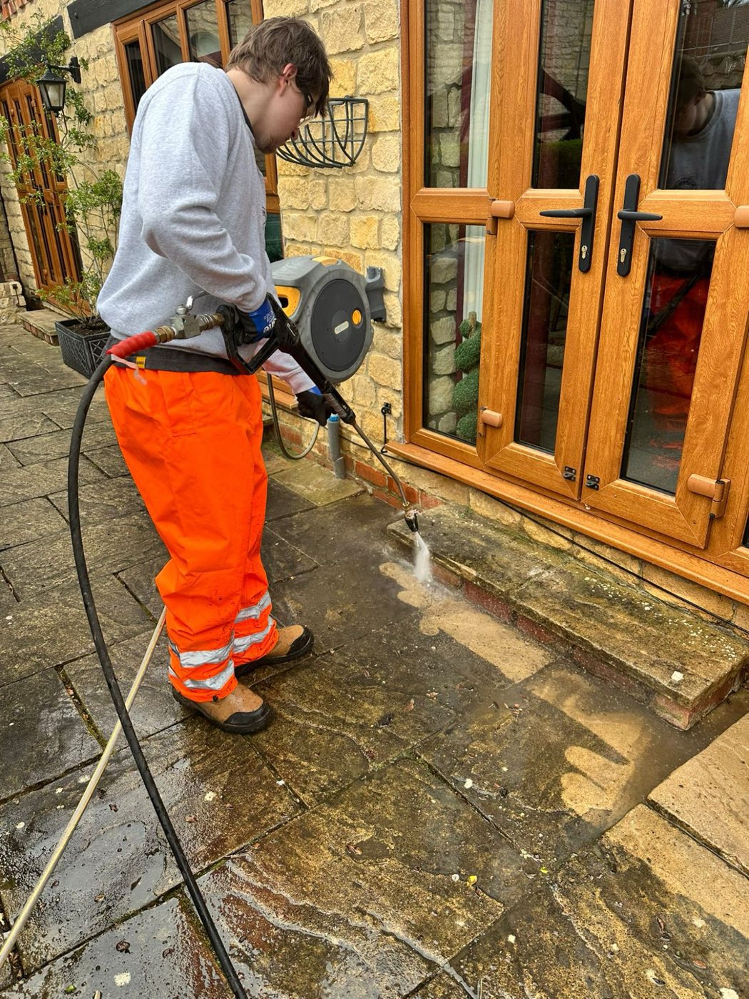 Pressure washing paving by patio doors