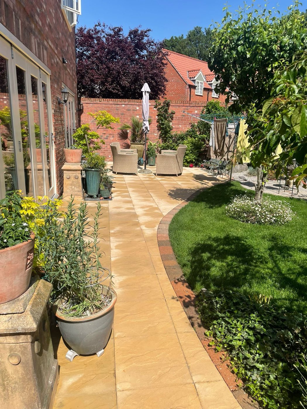 Clean garden path lined with potted plants
