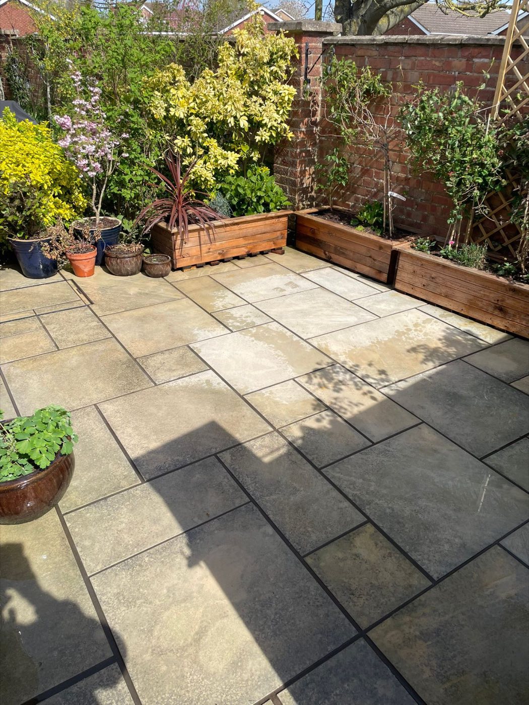 Clean buff paving patio with planters
